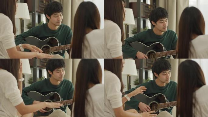 年轻人和他的朋友在家里弹吉他