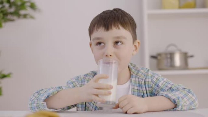 高兴的孩子在家里享受美味的牛奶，强壮的骨头，孩子的牙齿，钙