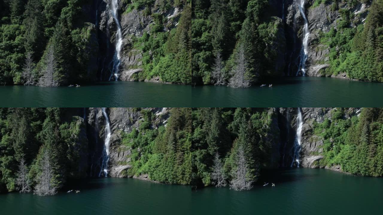 空中无人机拍摄了两名皮划艇运动员在瀑布附近的湖上划桨