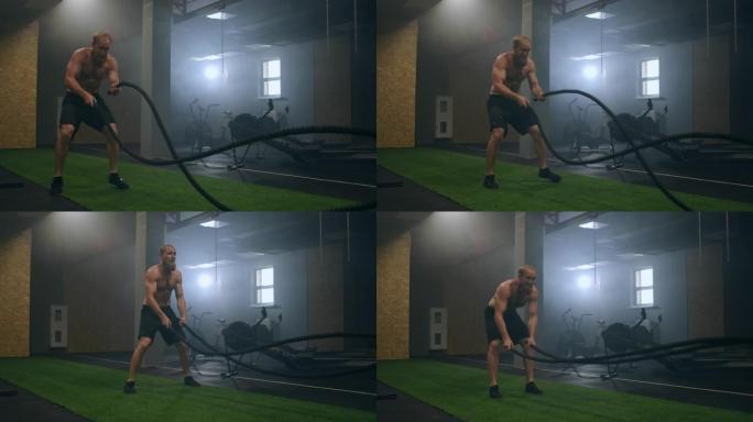 健身运动员使用战斗绳进行训练激烈的锻炼在健身房享受健康的健美耐力练习生活方式慢动作