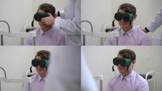 白人男子在医生就诊时的肖像，无法辨认的眼科医生戴上眼镜进行色盲测试，通过相机离开。医院的男性患者和女