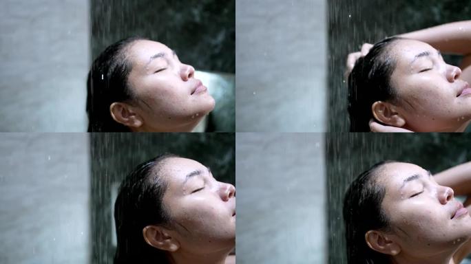 亚洲女孩她正在雨滴淋浴中洗澡