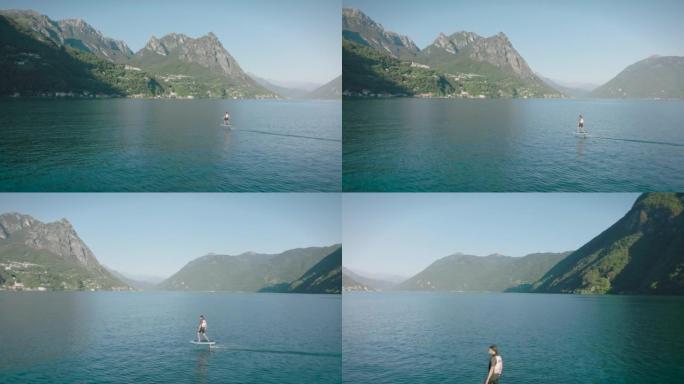 骑电动箔纸在平静的湖上滑行的人包围了我的山脉