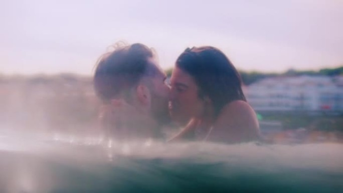 浪漫的异性恋夫妇一起在海里游泳。互相拥抱和旋转