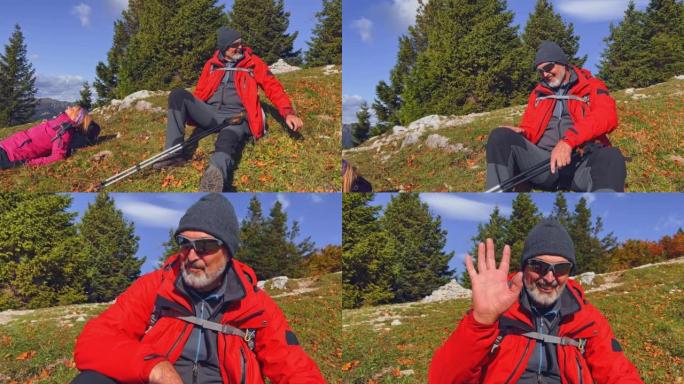 SLO MO高级男徒步旅行者在阳光明媚的山顶上放松时微笑着向镜头挥手