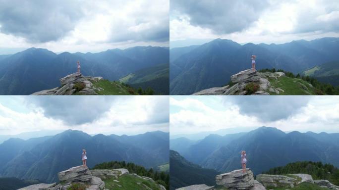 女人站在岩石山脊上，远处的山脉