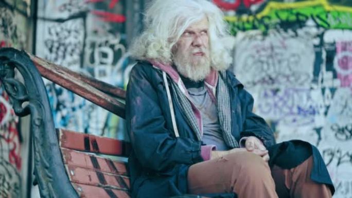 无家可归的老人独自坐在破板凳上，贫穷和社会不公