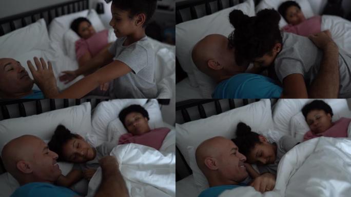 床上的女孩与聋哑的父亲交谈并拥抱父母
