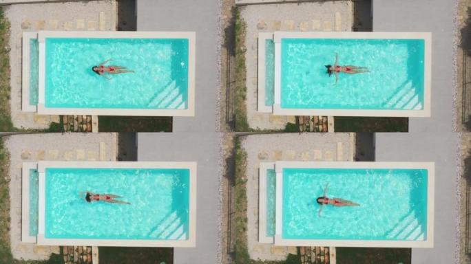 空中无人机拍摄了一名漂浮在游泳池中的妇女