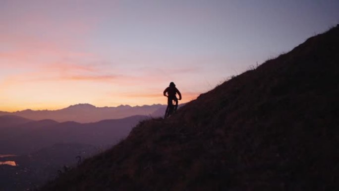 日落之后，在蓝色时刻，山地车手在山顶上骑行