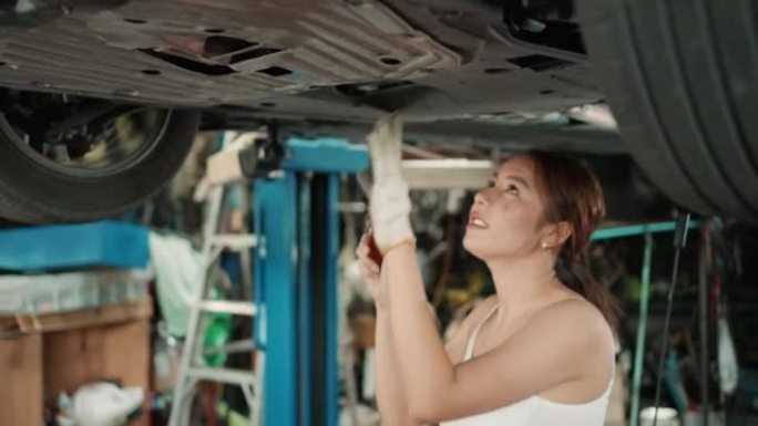 女发动机工程师在汽车修理店修理汽车