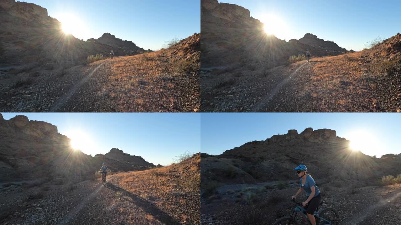 女性山地自行车手沿着沙漠小路