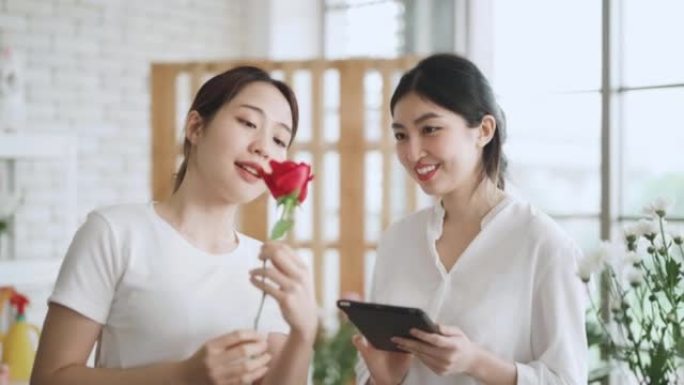 两名亚洲女花店小企业主在花店布置花束