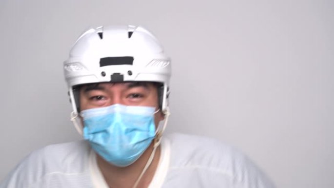 冰球运动员在白底戴防护面具