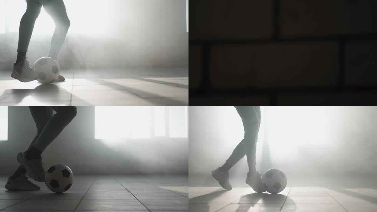 近距离足球在阳光下在地下停车场慢动作运球。在城市环境中随球奔跑。训练一个梦想成为足球运动员的男孩