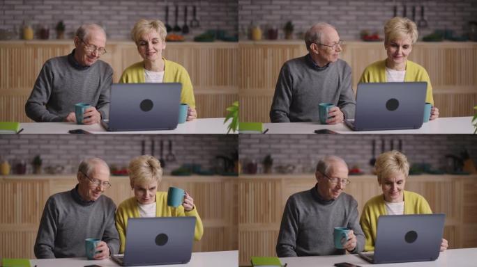 与朋友或家人的在线视频聊天，祖父和祖母的肖像看着笔记本电脑的显示器，坐在家里的厨房里