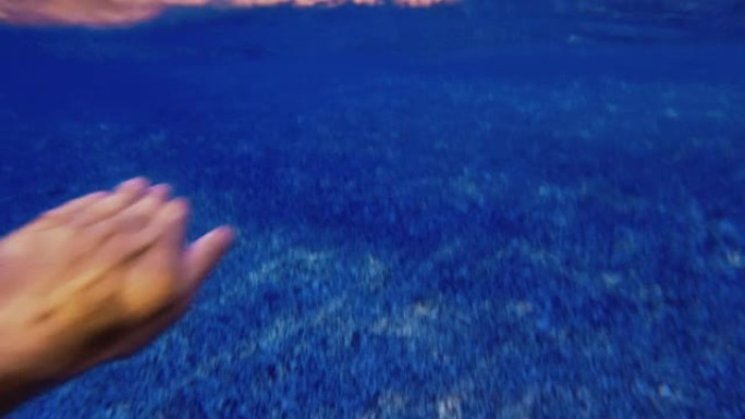 一个男人在蓝色的大海中游泳和浮潜的POV