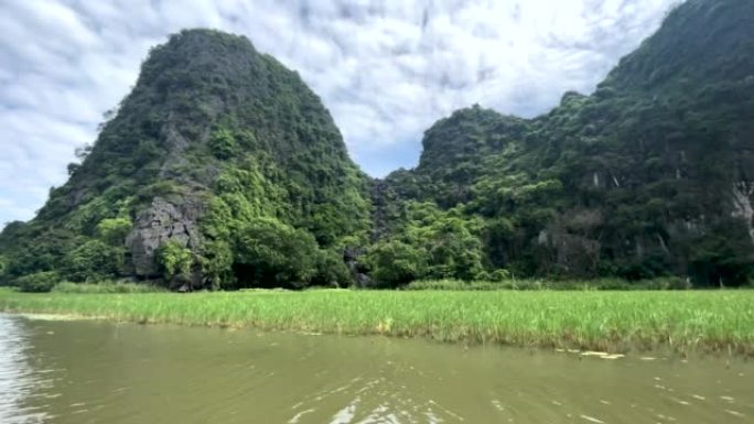 越南北部宁平省的Tam Coc洞穴和湖泊的美丽船景，在炎热的夏日里，有令人惊叹的山脉、岩石和稻田。