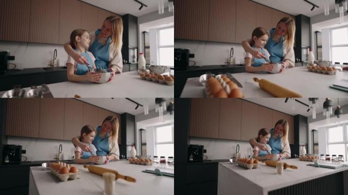 快乐的小女孩和她的木乃伊在一起做饭，母亲在教女儿做饭，一家人在家打发时间
