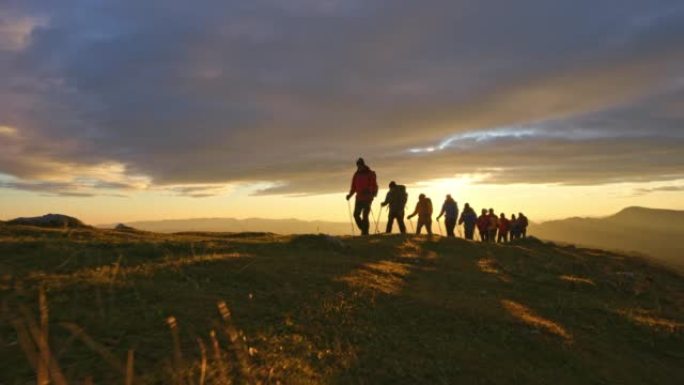 太阳下山时，空中SLO MO徒步旅行者在山顶上行走