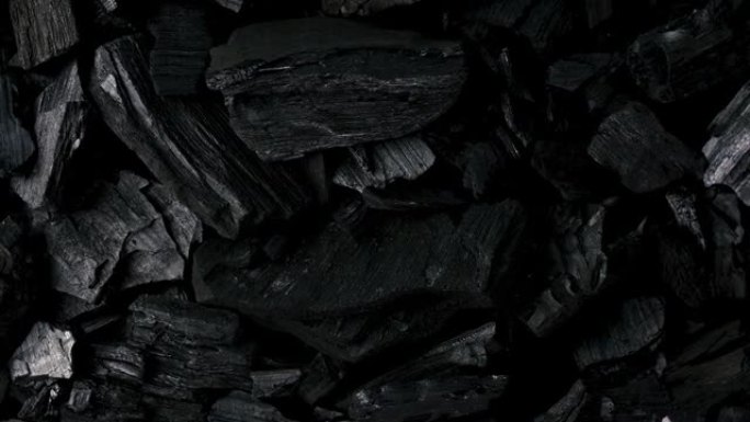 用于工业和食品制备的堆天然木炭矿物的黑色背景旋转。