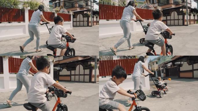可爱的亚洲男孩和他的兄弟在户外骑自行车
