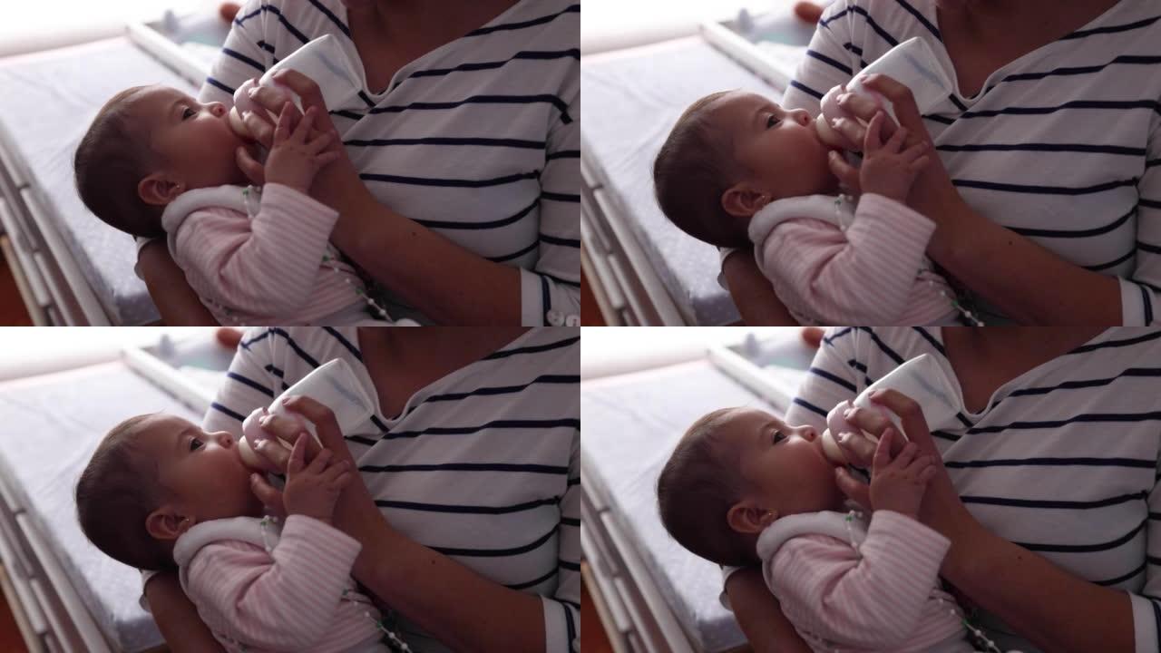 无法辨认的母亲在喂养她时抱着一个带有髋关节发育不良支架的女婴的特写镜头