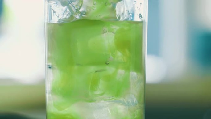 倒入玻璃杯中的绿色饮料的细节照片