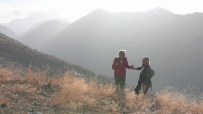 成熟的徒步旅行夫妇在山腰享受时光