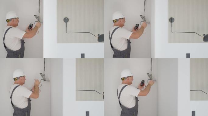 男性电工在智能家居系统中安装用于照明的变压器。安装照明