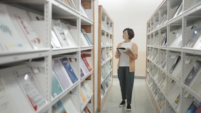 亚洲妇女在图书馆寻找书籍