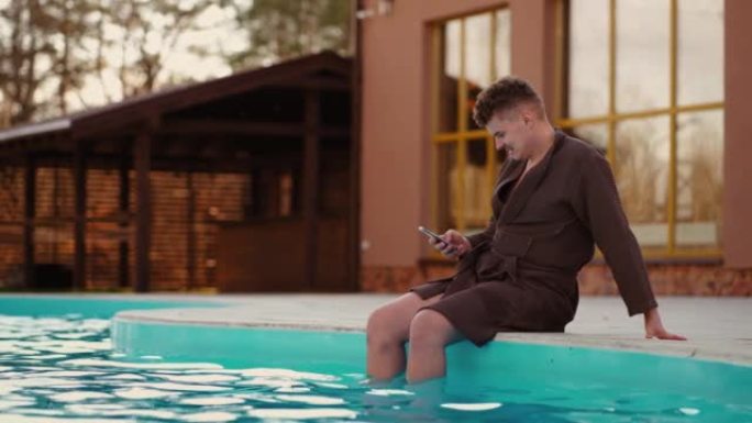 放松的人在室外公园游泳池休息，用现代智能手机浏览社交媒体