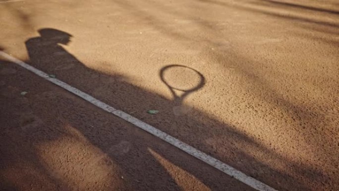 Shadow cast by player bouncing ball with racquet o