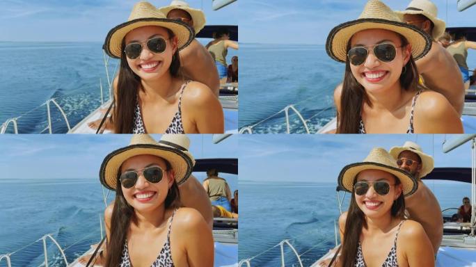 年轻女子在游艇上晒日光浴时对着镜头微笑