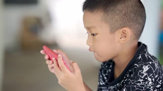 玩手机的亚洲孩子。