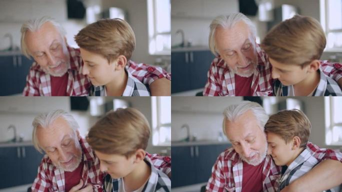 善良的祖父拥抱孙子，在家和男孩说话，长大，爱
