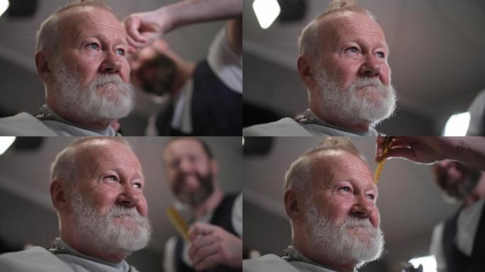 个人美容，迷人的老人削减他的胡子和头发在一个现代沙龙的理发师，而坐在理发椅上，特写