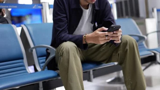男子在航空公司的登机休息室使用智能手机