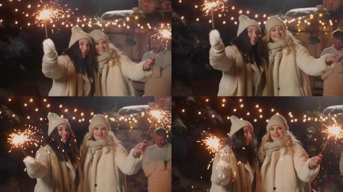 两个快乐的女人在城市集市广场庆祝圣诞节和新年，午夜肖像
