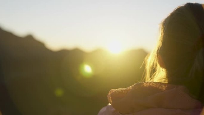 看着山日落的年轻女子。宁静的风景