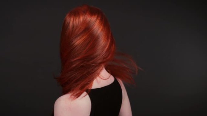 迷人的红发女人翻转她长长的直发。