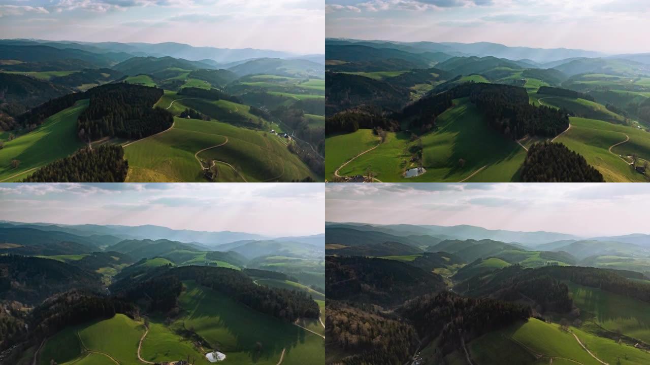 空中无人机拍摄日落时丘陵起伏的乡村小镇