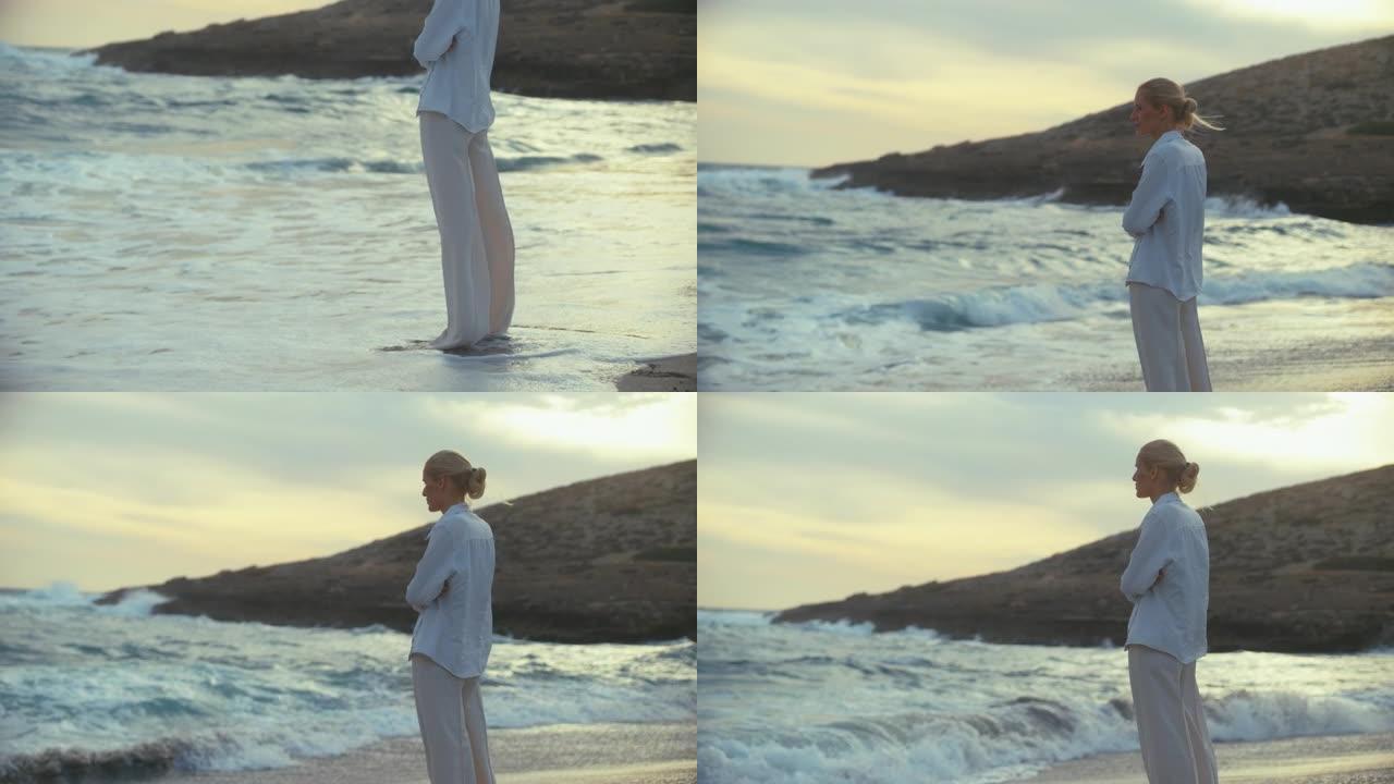 独自站在海滩上的女人。望向遥远的大海，享受微风