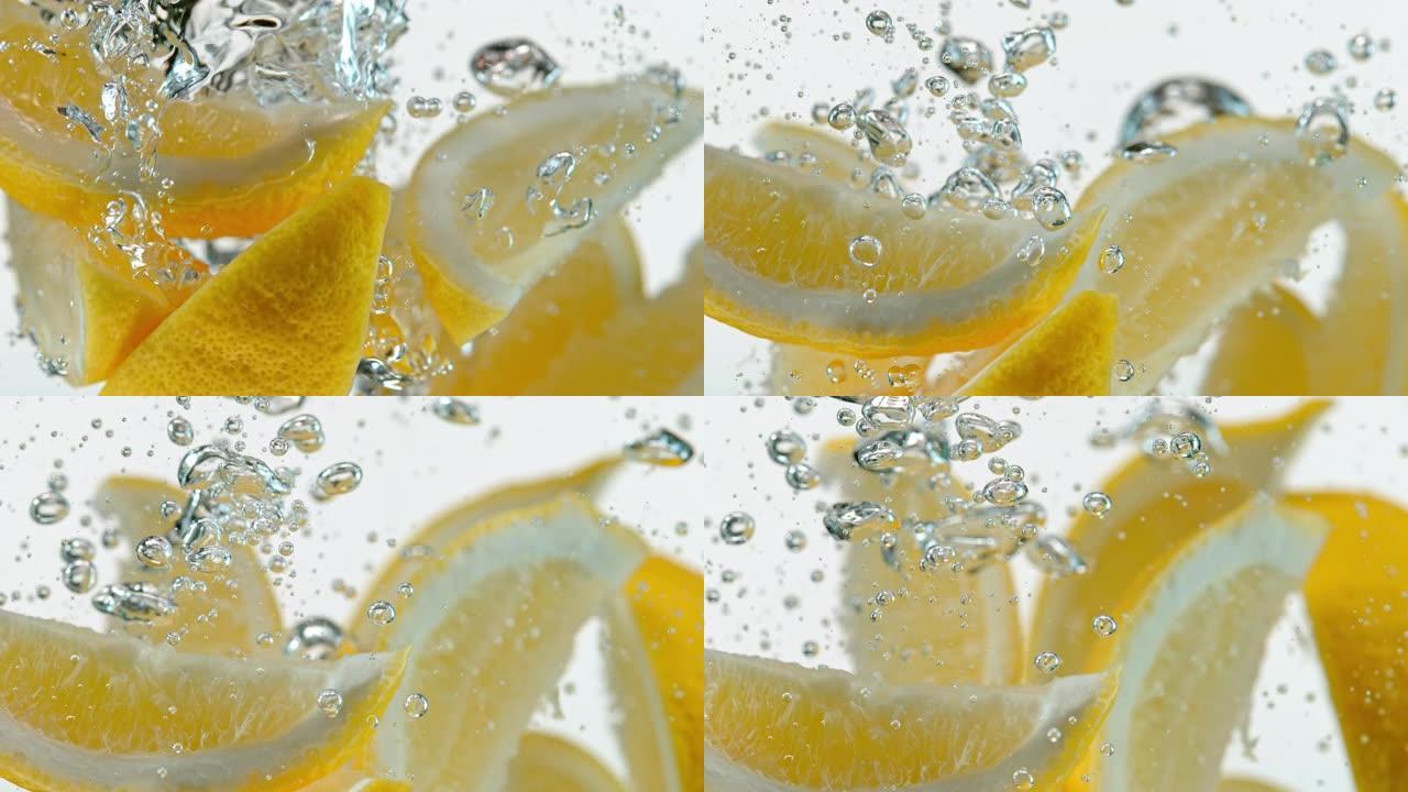 SLO MO LD柠檬楔子在白色背景下落入水中