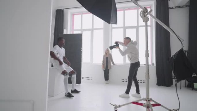 摄影师正在摄影棚里用球捕捉职业足球运动员，杂志内容