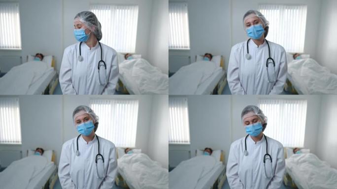 疲惫的护士戴着冠状病毒口罩，回头看病人摇头，看着相机叹息。在医院病房摆姿势的疲惫悲伤的高加索妇女的中