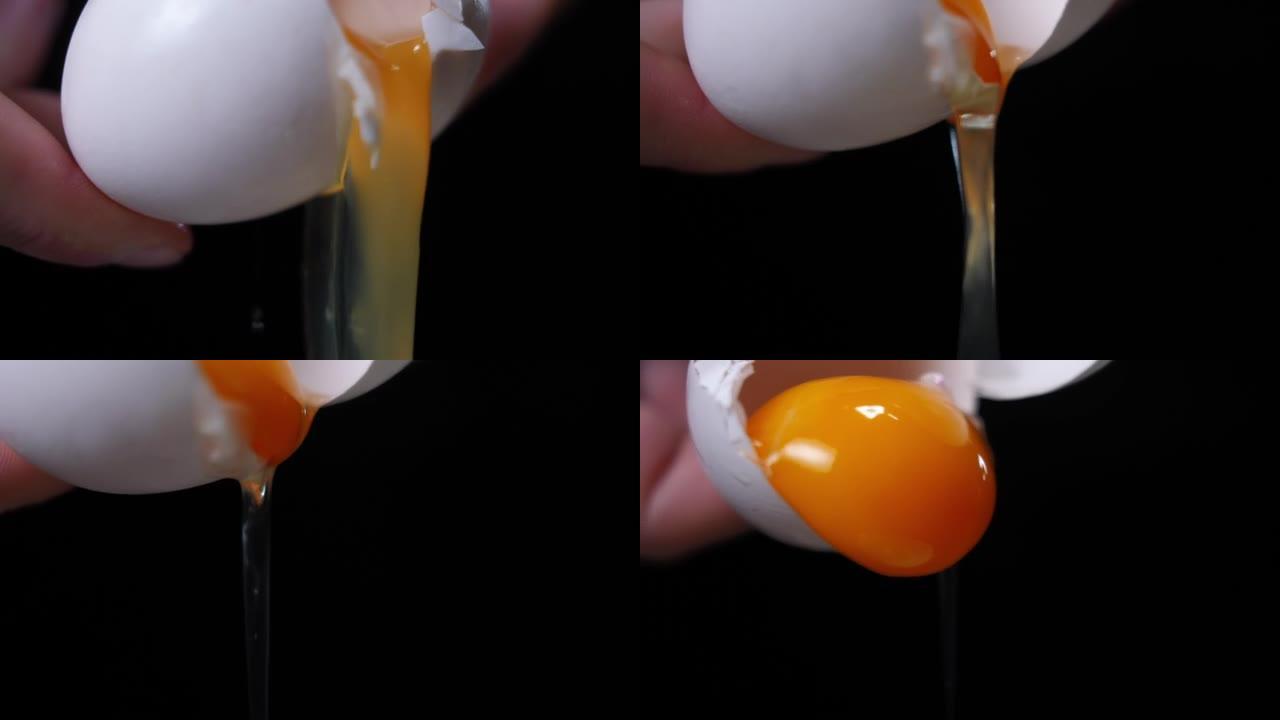 近距离打开雌性高加索人手中的鸡蛋，白色和蛋黄以慢动作倾泻下来。无法辨认的女人在黑色背景下做饭。