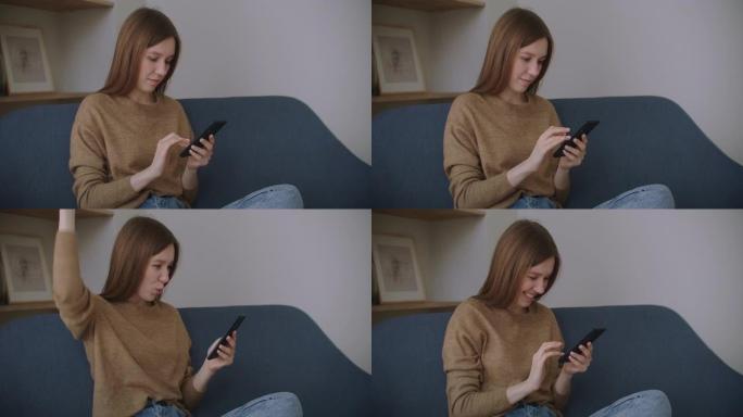 女商人在家庭办公室用手机打字信息。年轻女孩在电话里慢动作聊天。在沙发上使用智能手机关闭年轻女性的手。