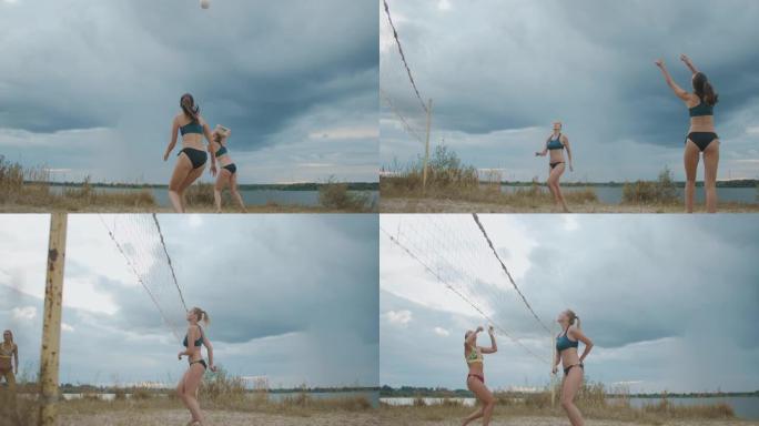 夏天，穿着运动比基尼的美丽苗条的女人在沙滩上打排球，慢动作射击