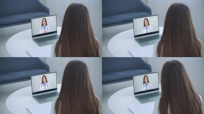 肩部观察年轻女性在第一次病毒疾病症状、医疗保险、covid19传播后，通过笔记本电脑上的视频通话在线